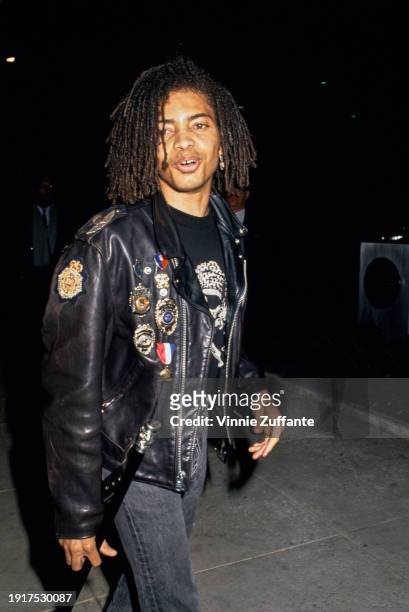 American singer and songwriter Terence Trent D'Arby, wearing a black leather jacket with badges pinned to it over a black t-shirt with a...