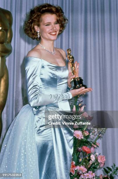 American actress Geena Davis wearing an off-shoulder blue evening gown, in the press room of the 61st Academy Awards, held at the Shrine Auditorium...