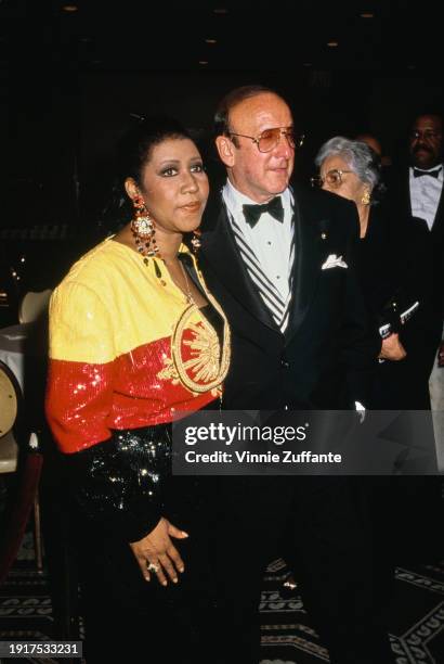 American singer and songwriter Aretha Franklin, wearing a black, red and yellow outfit and American music executive Clive Davis, who wears a tuxedo...