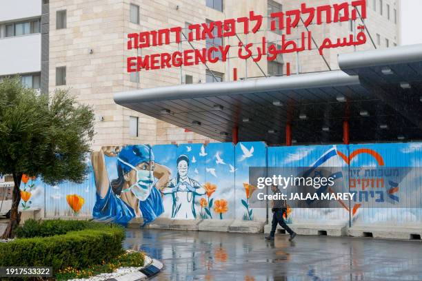 An armed man walks outside the Ziv Hospital in the northern Israeli city of Safed on January 11 amid increasing cross-border tensions with Lebanon,...