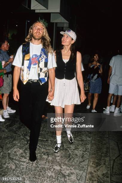 Finnish film director Renny Harlin, wearing a Planet Hollywood t-shirt, and his wife, American actress Geena Davis, who wears a white dress with a...