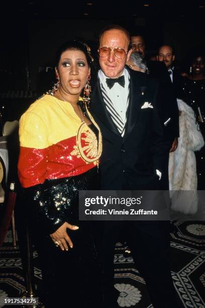 American singer and songwriter Aretha Franklin, wearing a black, red and yellow outfit and American music executive Clive Davis, who wears a tuxedo...