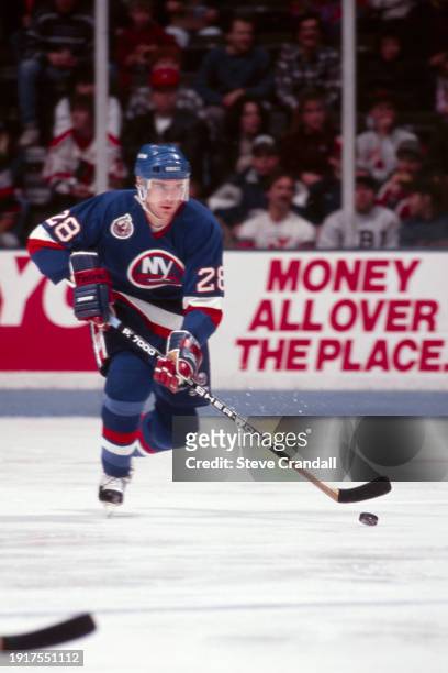 New York Islander's defenseman, Tom Kurvers, carries the puck out of the Islander's during the game against the NJ Devils at the Meadowlands Arena...