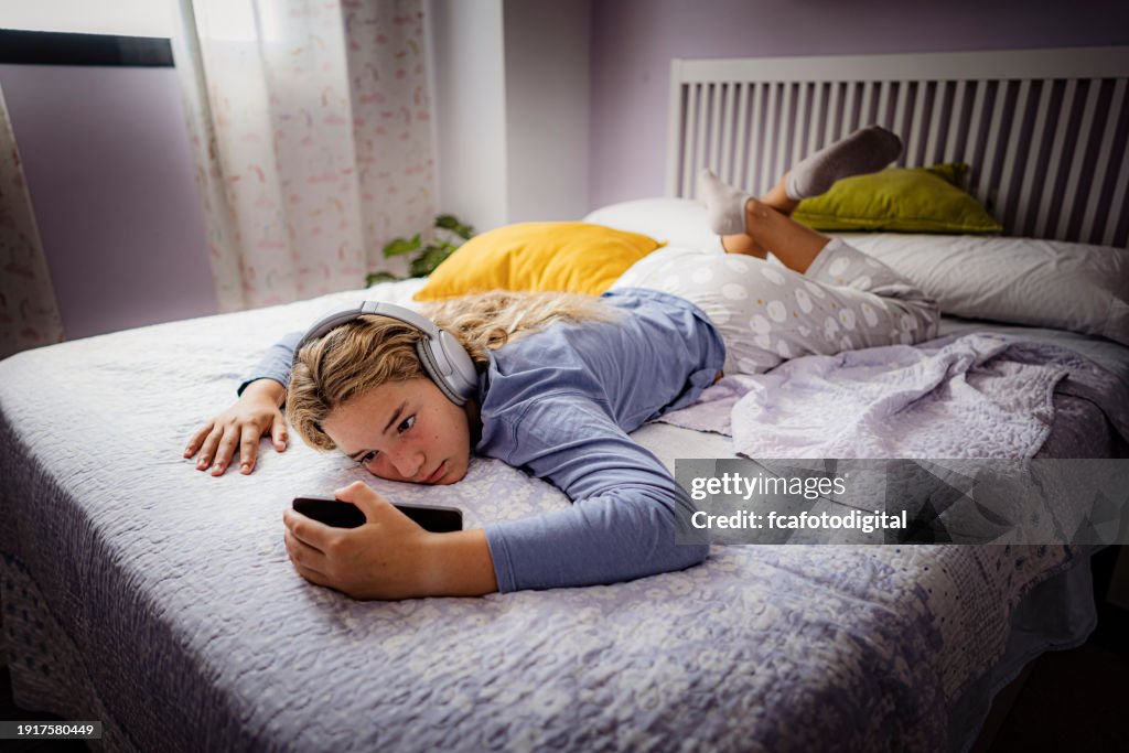 Teenager girl sitting in her bed feeling lonely and sad