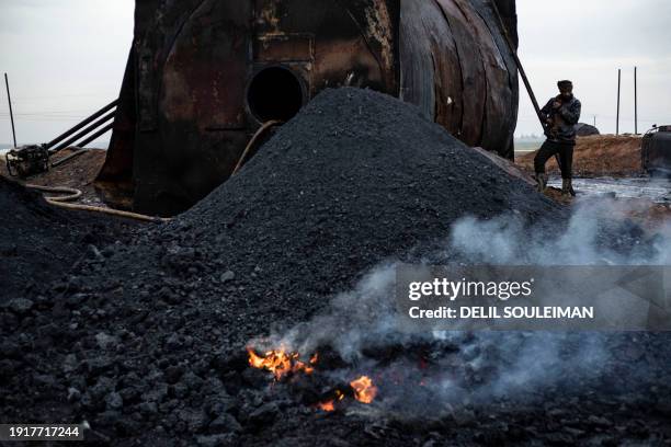 Picture taken on January 11 shows a worker at a primitive oil facility in the Abu Ghadir area, of Syria's northeastern Kurdish-controlled Qamishli...