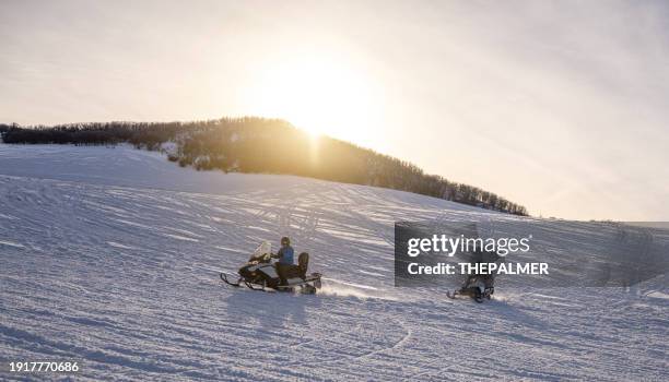 two guys driving a snowmobiles in colorado, usa - snowmobiling stock pictures, royalty-free photos & images