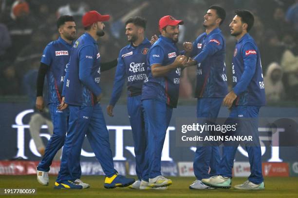 Afghanistan's Gulbadin Naib celebrates with teammates after taking a catch to dismiss India's Tilak Varma during the first Twenty20 international...