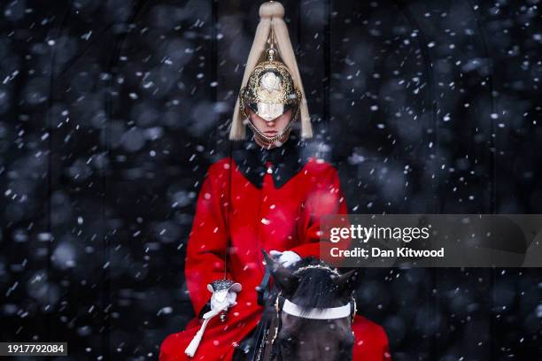 Snow falls near the Household Cavalry in Westminster on January 8, 2024 in London, England. Residents in London and the South East woke up to a...