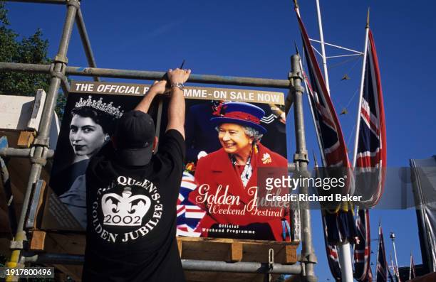 Retailer secures posters of Queen Elizabeth II on the occasion of the monarch's Golden Jubilee weekend Festival, on 1st June 2002, in London,...