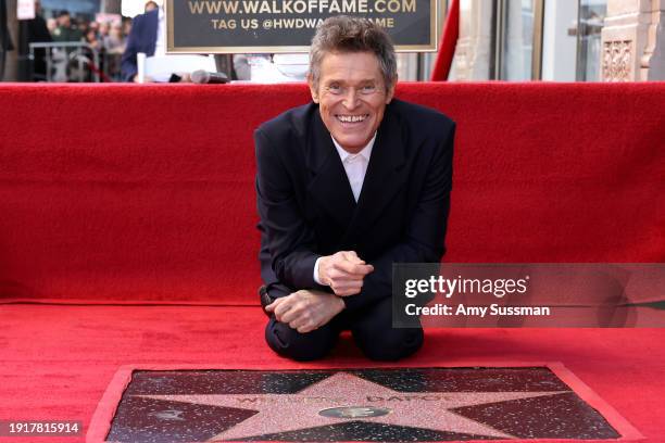Willem Dafoe poses with his star during his Hollywood Walk of Fame Star Ceremony on January 08, 2024 in Hollywood, California.
