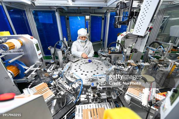 Worker is placing lighting components on crystal displays and modules on a production line at a semiconductor production workshop in Gao'an, Jiangxi...