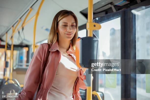 female commuter paying contactless with bank card in the public transport - bus card scan stock pictures, royalty-free photos & images