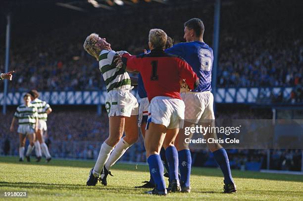 Frank McAvennie of Celtic is grabbed by the throat by a Rangers player as Chris Woods and Terry Butcher also of Rangers step in during the Scottish...