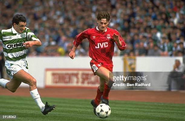 David Robertson of Aberdeen runs with the ball as Paul McStay of Celtic catches up during the Scottish Cup final match at Hampden Park in Glasgow,...