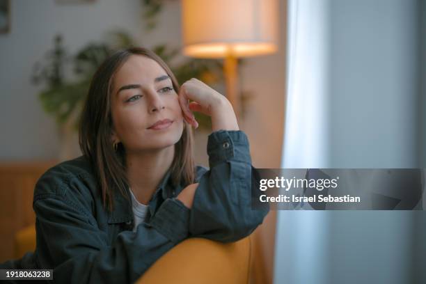 a beautiful woman looks through a window. - fashion suit stock pictures, royalty-free photos & images