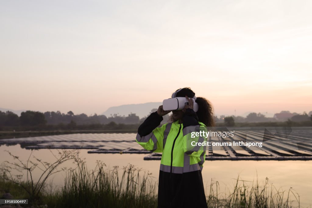Smart engineering woman using VR working on site of floating solar panels