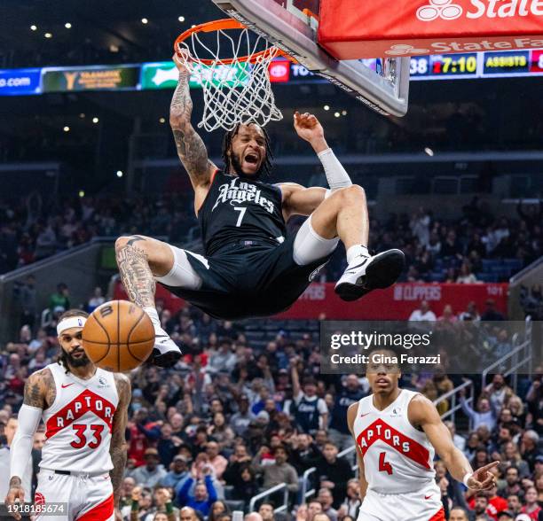 Clippers guard Amir Coffey reacts as he dunks over Toronto Raptors guard Gary Trent Jr. And Toronto Raptors forward Scottie Barnes in the first half...