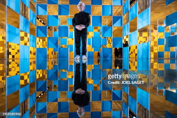 French artist Daniel Buren poses inside one of his installations during his exhibition entitled "Aux Beaux Carres" at the department store Le Bon...