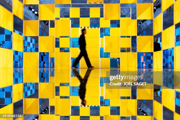 People visit installations by French artist Daniel Buren displayed as part of the exhibition entitled "Aux Beaux Carres" at the department store Le...