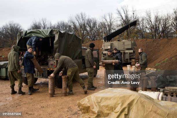 Israeli soldiers of the artillery unit carry propellants cases near the border with Lebanon on January 11, 2024 in Northern Israel, Israel. The war...