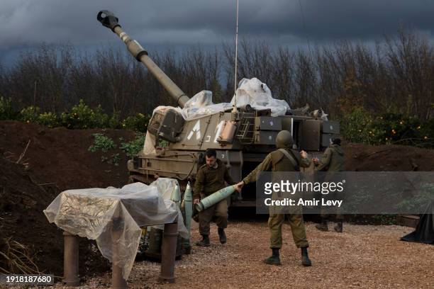 An Israeli soldier carries an explosive shell into artillery unit near the border with Lebanon on January 11, 2024 in Northern Israel, Israel. The...