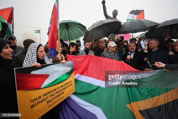 Palestinians carrying flags and banners gather at the Nelson Mandela Square to demonstrate in support of the 'genocide' case filed by the Republic of...