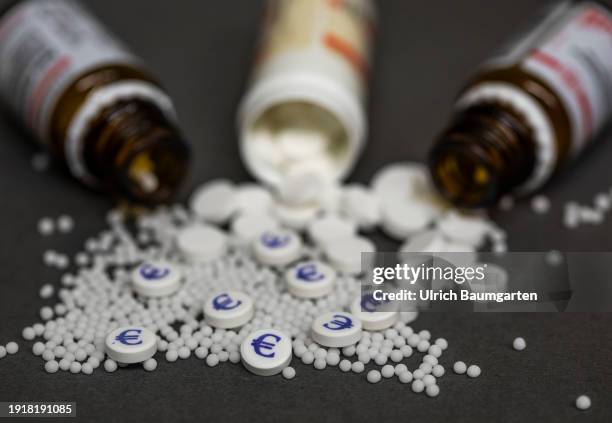 The illustration photo shows medicine bottles with homeopathic pills and tablets, some with a printed Euro symbol, on January 11, 2024 in Bonn,...