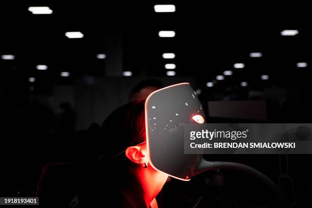 Person uses a red light mask from Lucibel.le Paris at the Venetian Expo Center during the Consumer Electronics Show in Las Vegas, Nevada, on January...