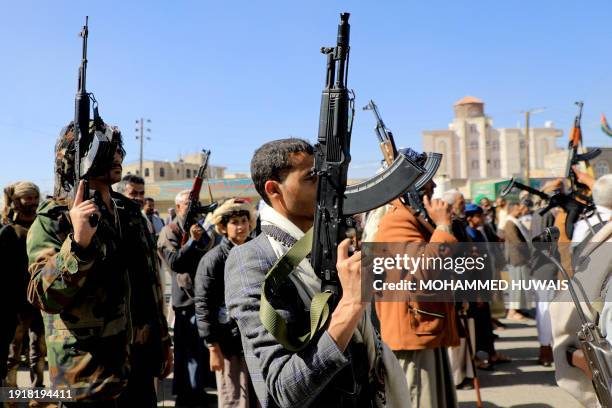 Huthi fighters brandish their weapons during a march in solidarity with the Palestinian people in the Huthi-controlled capital Sanaa on January 11...