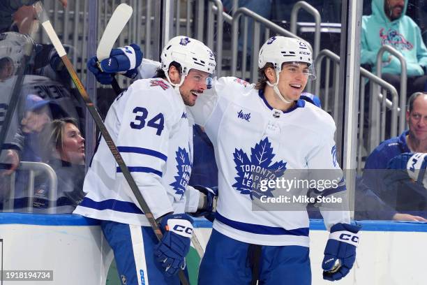 Auston Matthews of the Toronto Maple Leafs is congratulated by Matthew Knies after scoring a goal against the New York Islanders during the second...