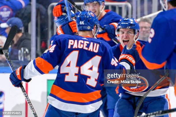 Mathew Barzal of the New York Islanders is congratulated by Jean-Gabriel Pageau after scoring the game-winning goal in overtime against the Toronto...