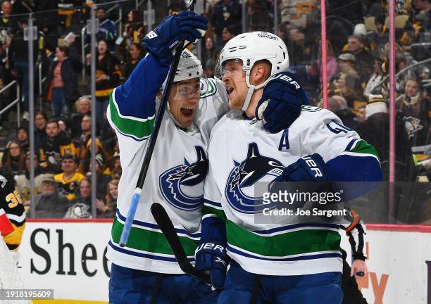 Elias Pettersson of the Vancouver Canucks celebrates his overtime goal with Andrei Kuzmenko against the Pittsburgh Penguins at PPG PAINTS Arena on...