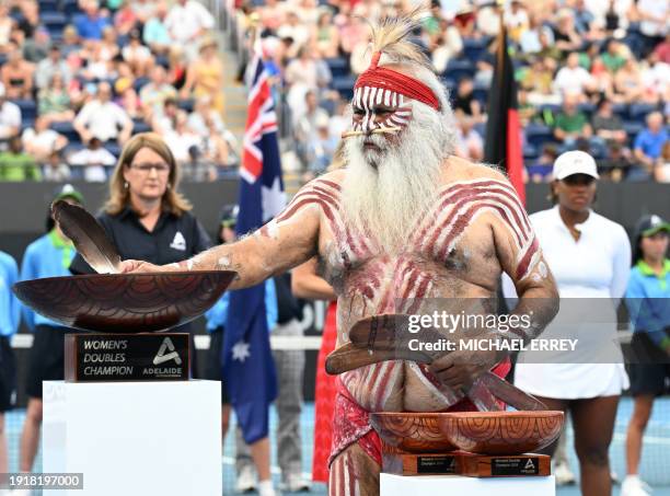 Uncle Moogy blesses the winners' trophy during the women's doubles final presentation of the Adelaide International tennis tournament in Adelaide on...