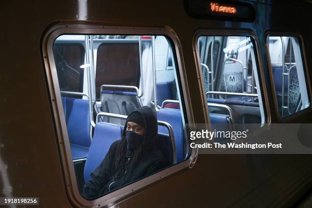 Passenger wears a face covering while riding a train passing through the Metro Center station on Thursday January 04, 2024 in Washington, DC. There...
