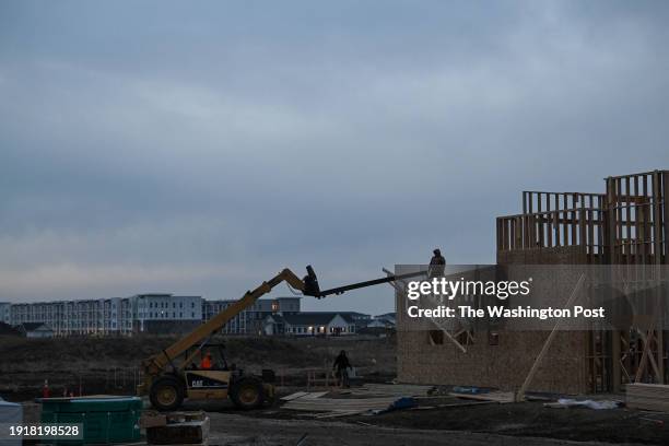 Construction workers build a Guadalajara Mexican Restaurant along Hickman Road as new homes are seen in the background on Friday, January 5, 2024 in...