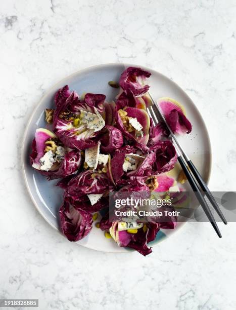 bowl of radicchio salad with walnuts and blue cheese on white, marble background - radicchio stock pictures, royalty-free photos & images