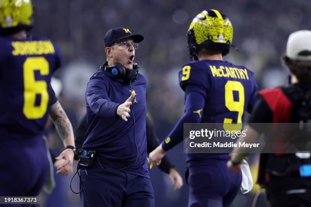 Head coach Jim Harbaugh of the Michigan Wolverines celebrates with J.J. McCarthy after a touchdown in the first quarter against the Washington...