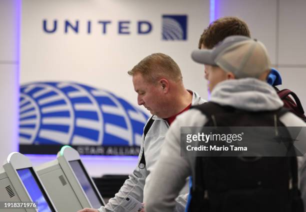 Travelers stand at a United Airlines check-in area at Los Angeles International Airport on January 8, 2024 in Los Angeles, California. Alaska...