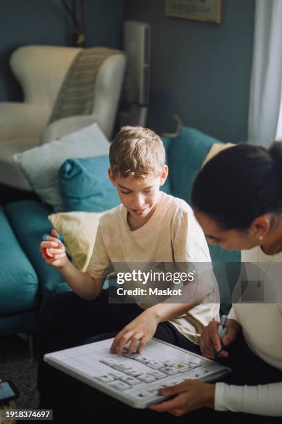 boy sitting with mother preparing weekly planner at home - add list stock pictures, royalty-free photos & images