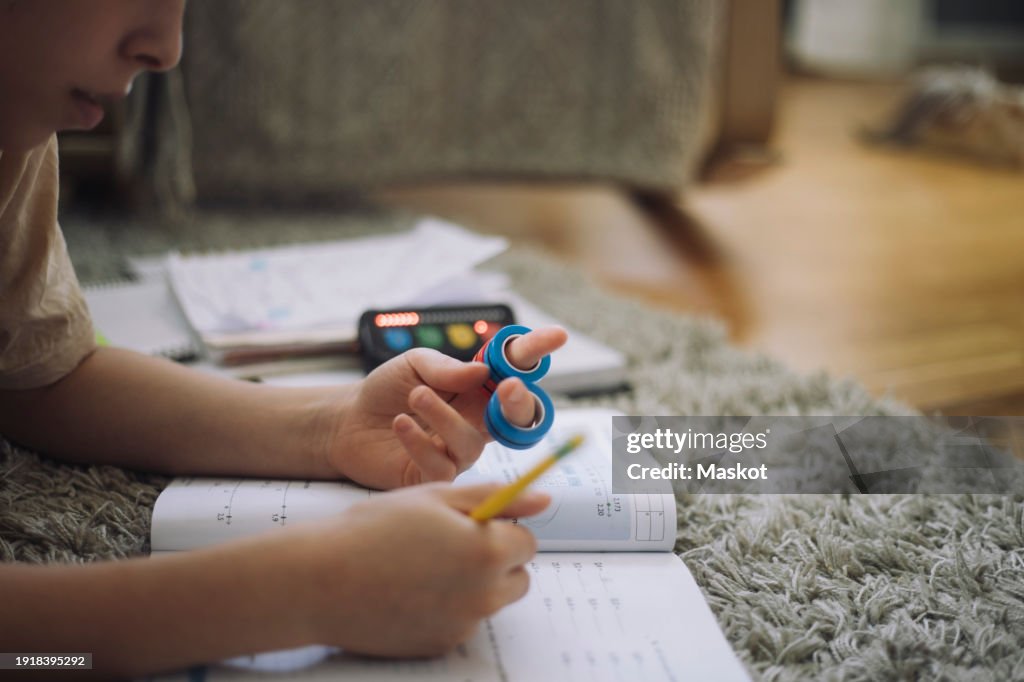 Toy Homework Boy Wearing Ring Toys On Fingers And Doing Homework While Lying Down On ...