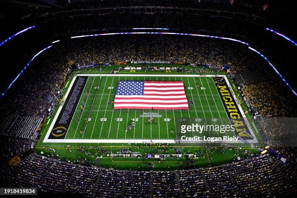 View of the American flag during the national anthem prior to the 2024 CFP National Championship game between the Washington Huskies and Michigan...