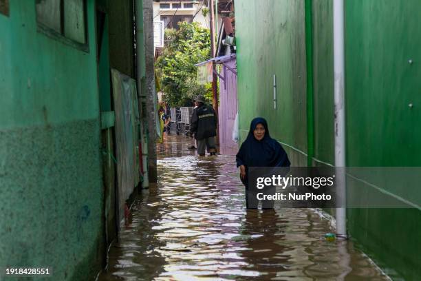 Woman is passing through floods in Dayeuhkolot, Bandung Regency, Indonesia, on January 12, 2024. The overflow of the Citarum River, due to the high...