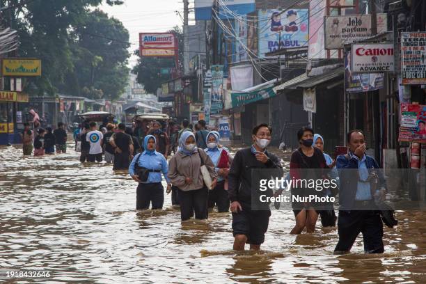 People are passing through floods in Dayeuhkolot, Bandung Regency, Indonesia, on January 12, 2024. The Citarum River is overflowing due to the high...