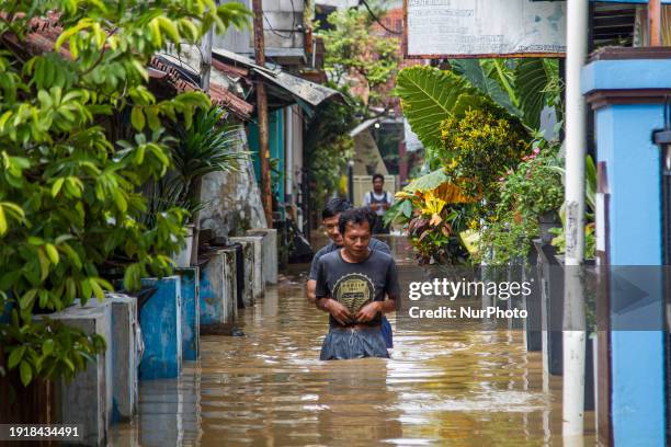 People are passing through floods in Dayeuhkolot, Bandung Regency, Indonesia, on January 12, 2024. The Citarum River is overflowing due to the high...