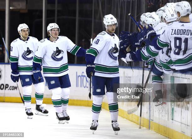 Elias Pettersson of the Vancouver Canucks celebrates his goal with teammates on the bench during the second period against the New York Rangers at...