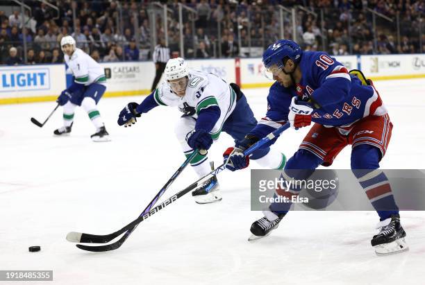 Artemi Panarin of the New York Rangers heads for the net as Tyler Myers of the Vancouver Canucks defends during the second period at Madison Square...