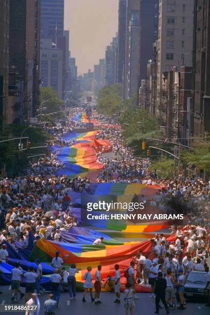 Gay marchers carry the mile long rainbow colored gay flag up First avenue in Manhattan in New-York on June 26, 1994. The march to Central Parks marks...