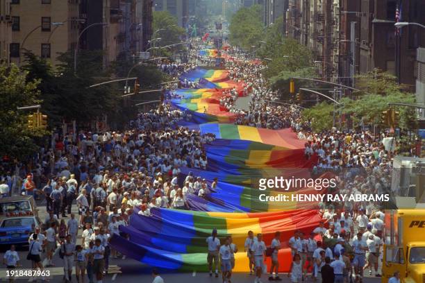 Gay marchers carry the mile long rainbow colored gay flag up First avenue in Manhattan in New-York on June 26, 1994. The march to Central Parks marks...