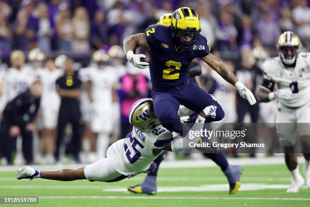 Blake Corum of the Michigan Wolverines runs the ball against Elijah Jackson of the Washington Huskies in the first half during the 2024 CFP National...