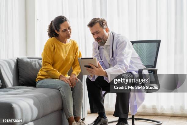 doctor talking with patient symptoms of muscle inflammation caused by sitting and working - medisch dossier stockfoto's en -beelden